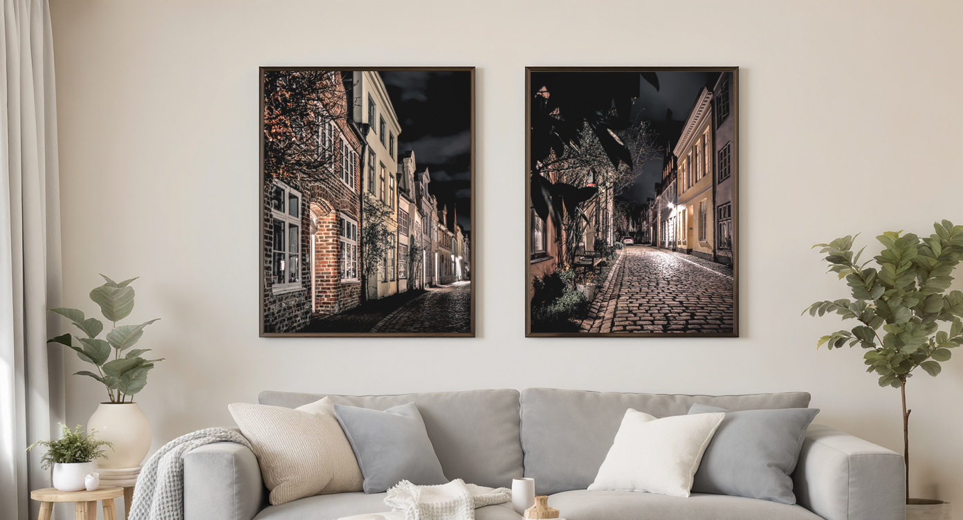 Zwei Nachtaufnahmen einer abendlichen Altstadtgasse in Lübeck als Wandbilder im Wohnzimmer.